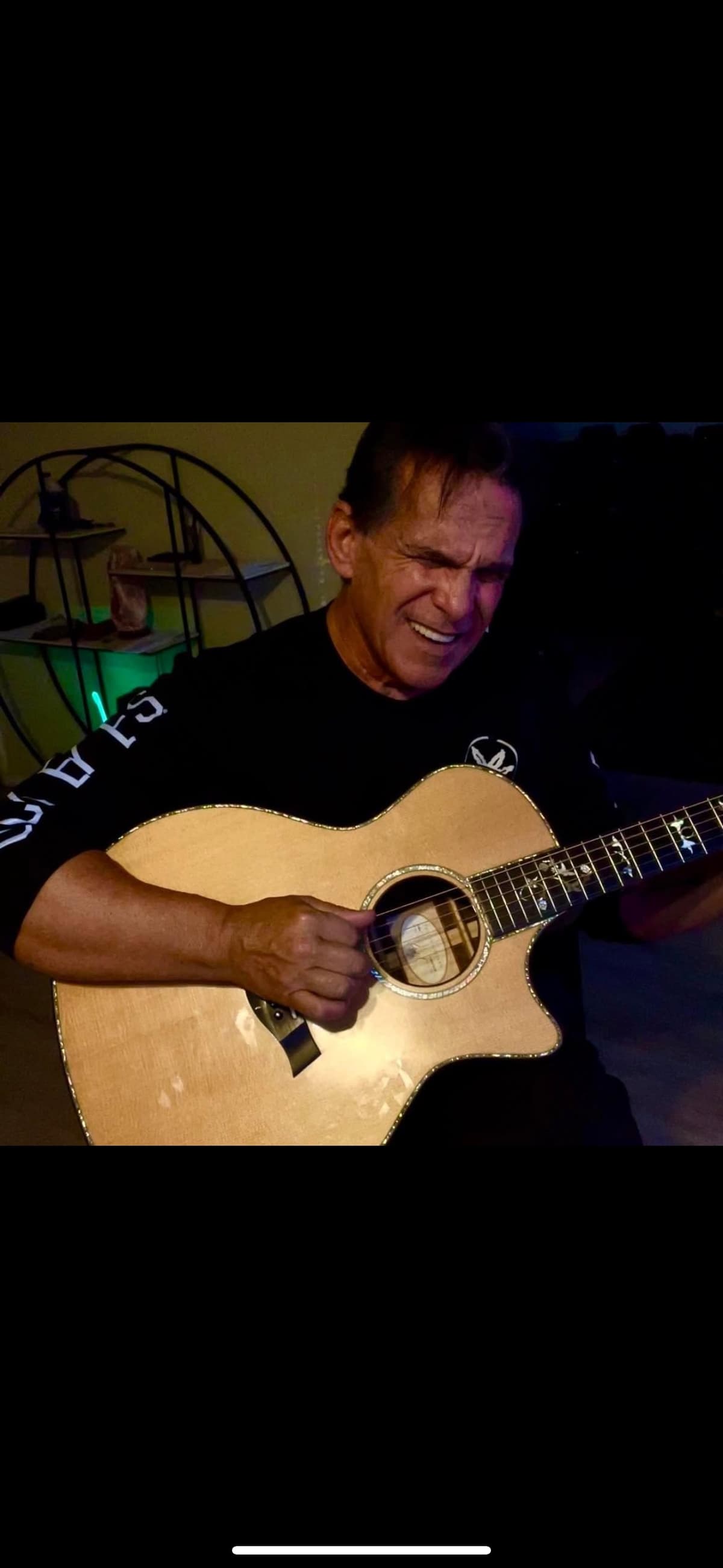 Mark DiPietro playing acoustic guitar